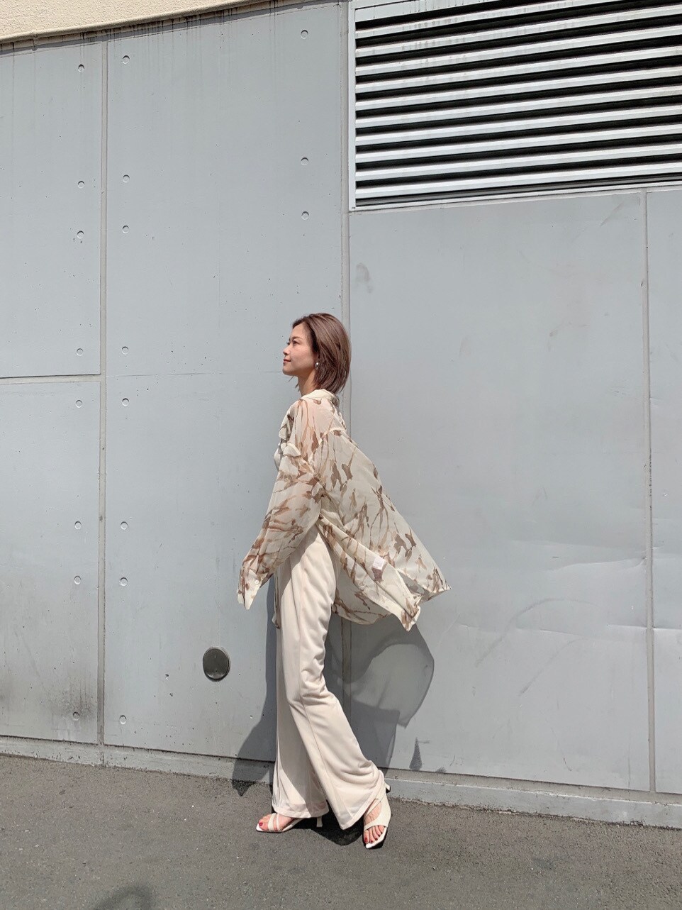 ホワイト系のスラックス、ホワイト系のサンダル、ホワイト系のTシャツ/カットソーを着用したレディースの春コーディネートの5枚目の写真