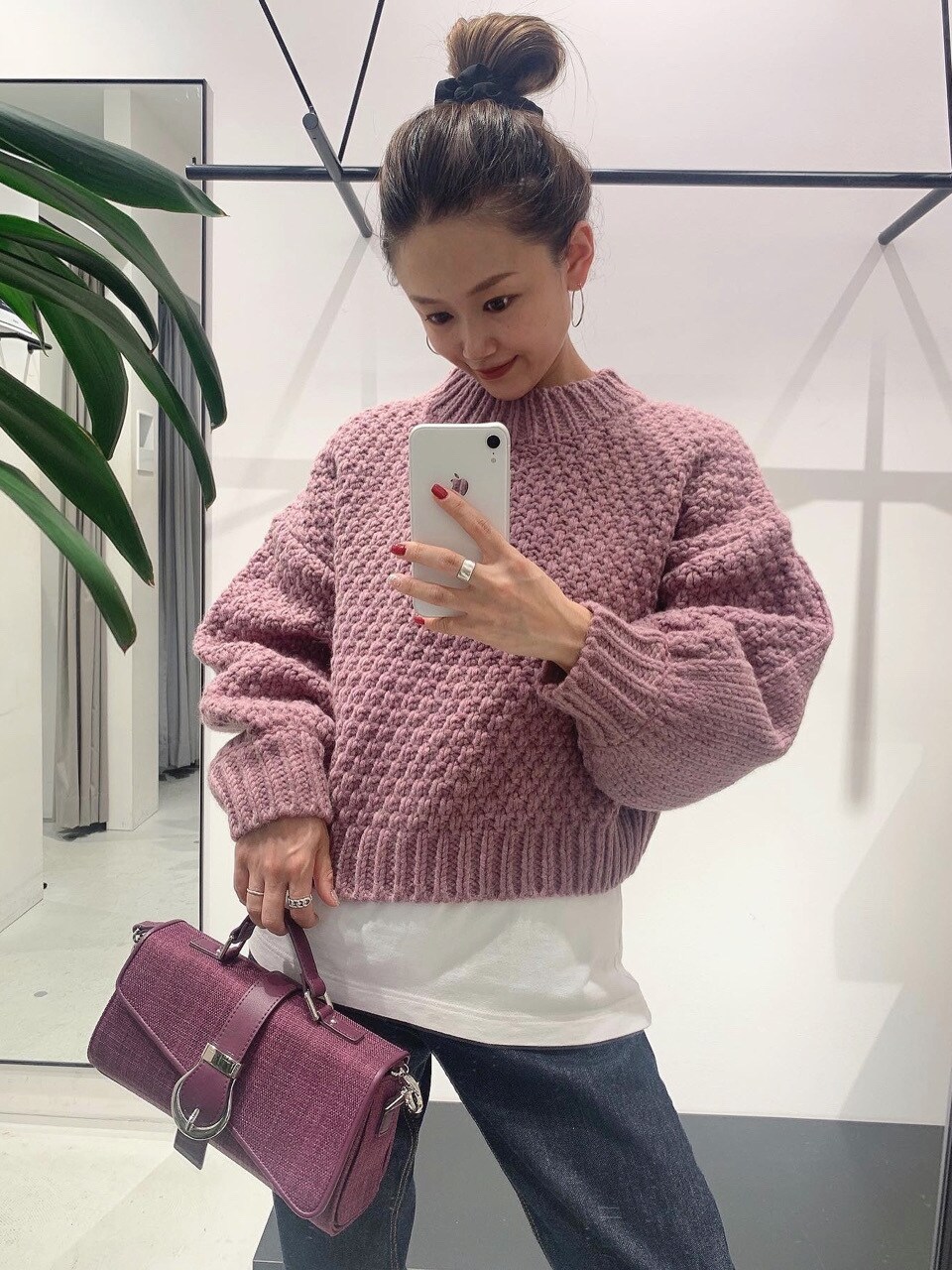 ホワイト系のブーツ、ブルー系のデニムパンツ、ピンク系のニット/セーターを着用したレディースの秋コーディネートの2枚目の写真