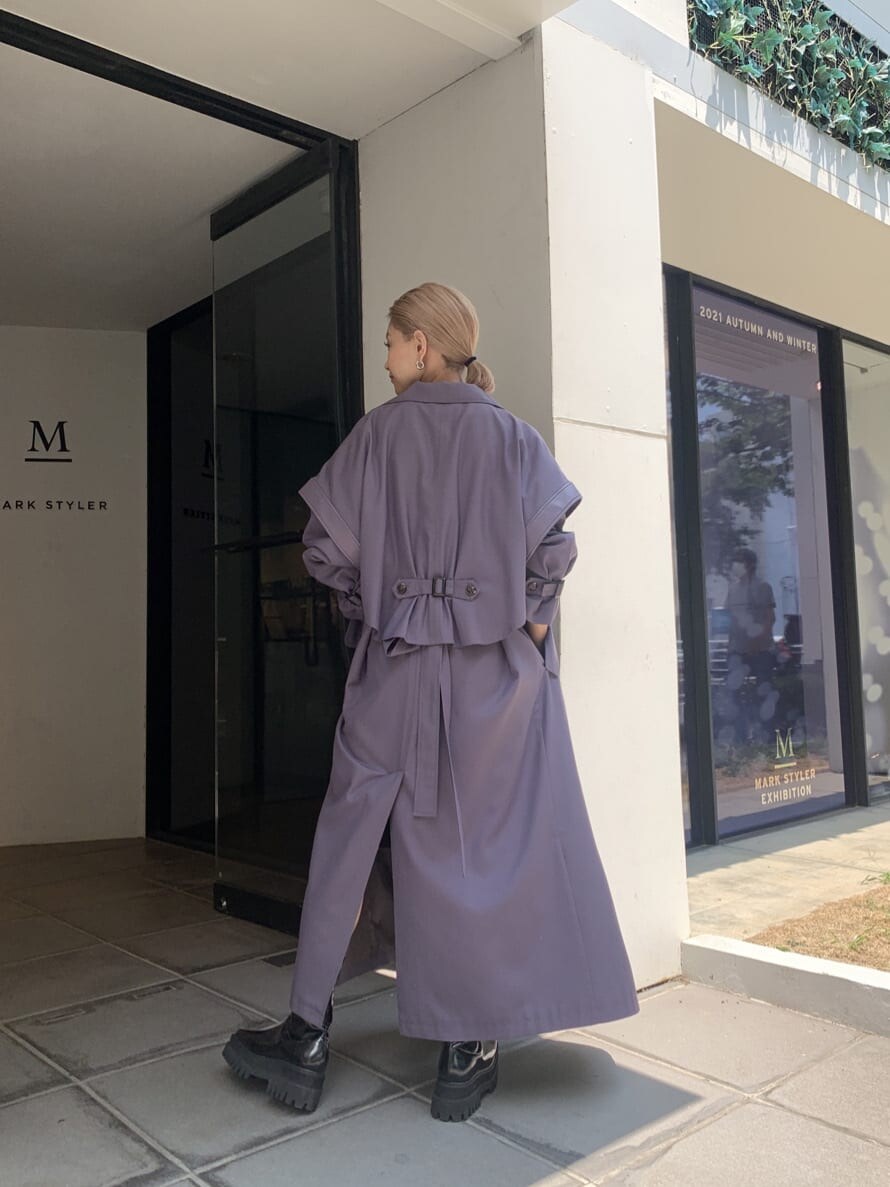 パープル系のトレンチコート、ブラック系のブーツを着用したレディースの夏コーディネートの3枚目の写真