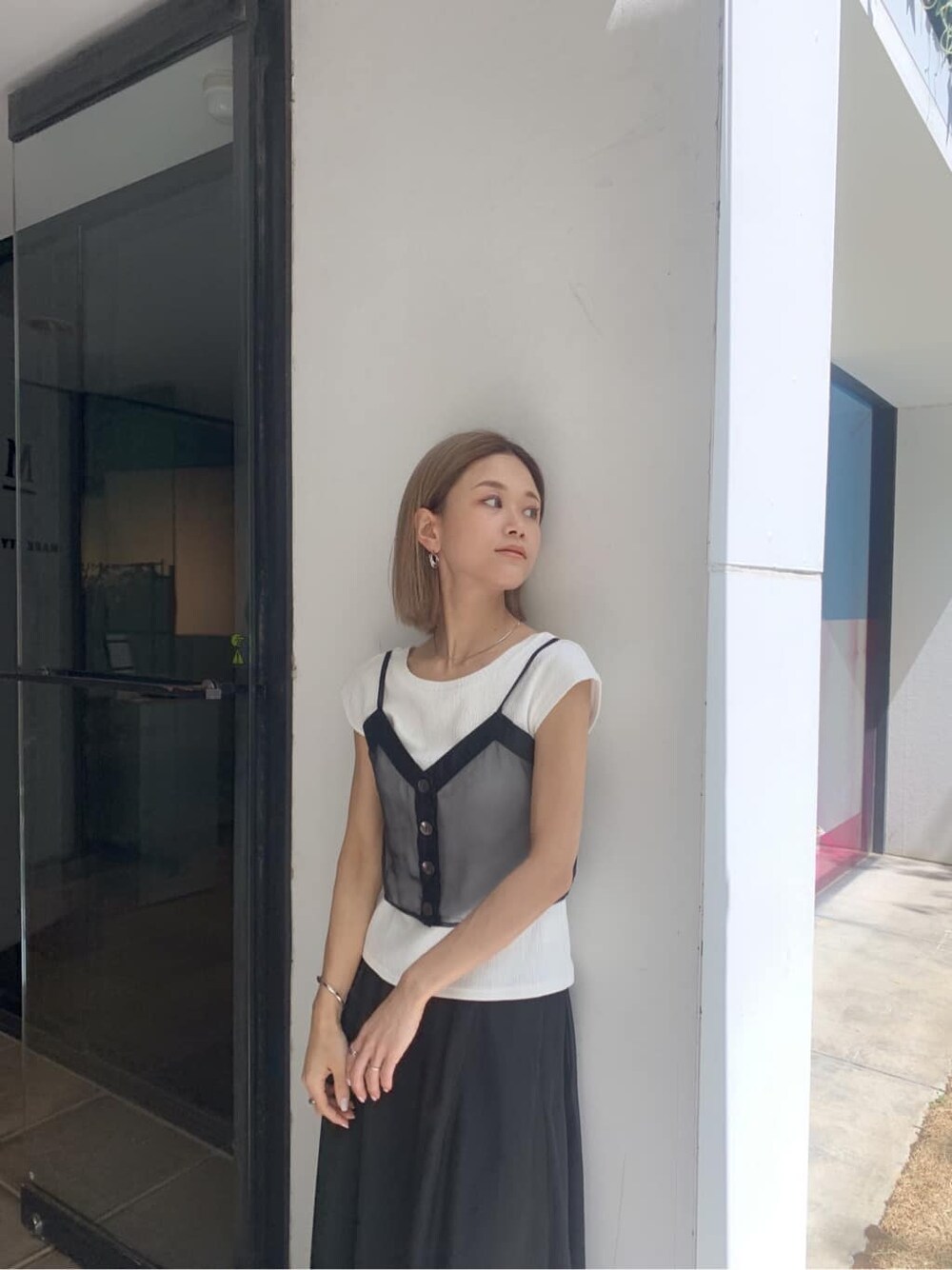 ブラック系のスカート、ブラック系のサンダル、ブラック系のTシャツ/カットソーを着用したレディースの夏コーディネートの2枚目の写真