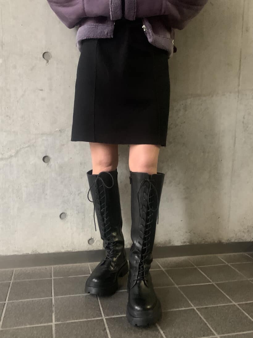 パープル系のブルゾン、ブラック系のワンピース、ブラック系のブーツを着用したレディースの冬コーディネートの4枚目の写真