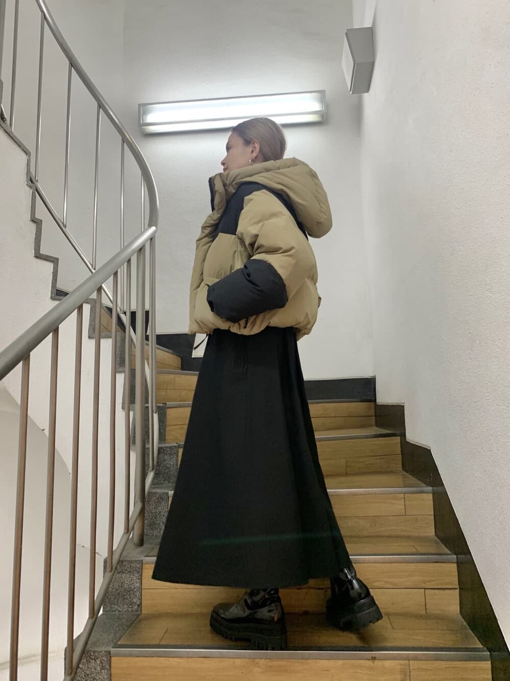 グリーン系のダウンジャケット/コート、ベージュ系のダウンジャケット/コート、ブラック系のブーツを着用したレディースの夏コーディネートの4枚目の写真