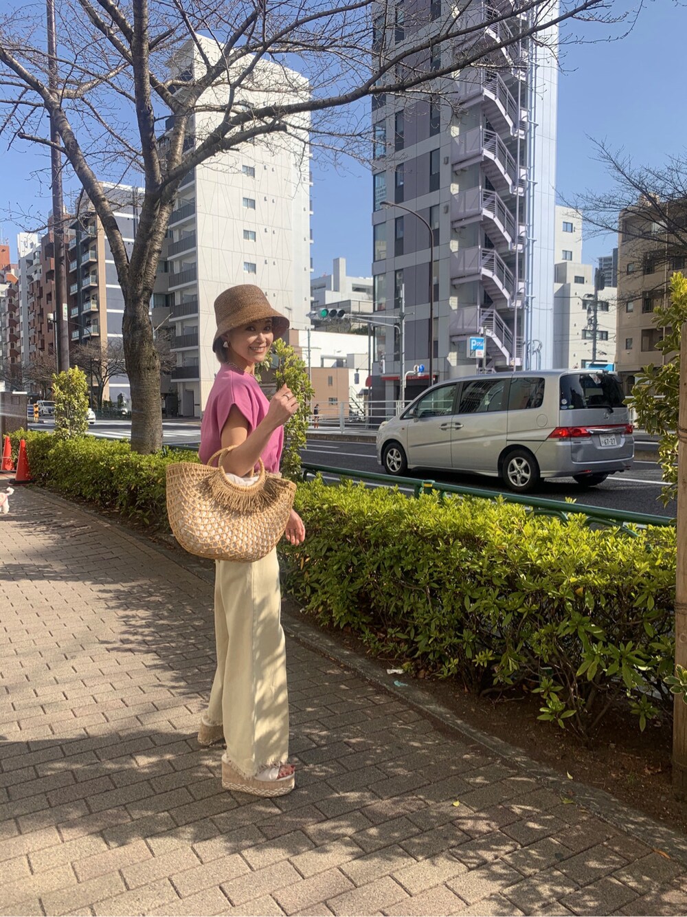 イエロー系のその他パンツ、ベージュ系のかごバッグ、ホワイト系のサンダルを着用したレディースの春コーディネートの2枚目の写真