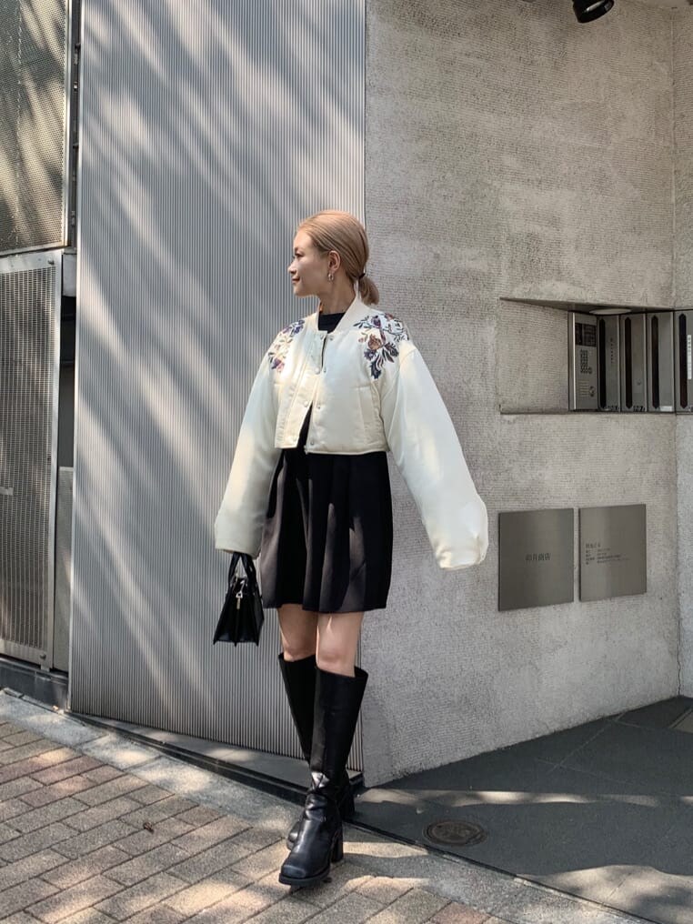 ブラック系のワンピース、ホワイト系のブルゾンを着用したレディースの夏コーディネートの3枚目の写真