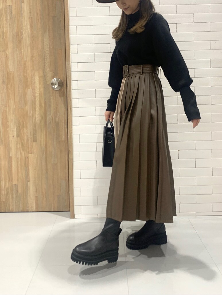 ブラウン系のスカート、ブラック系のニット/セーター、ブラウン系のハットを着用したレディースの冬コーディネートの3枚目の写真