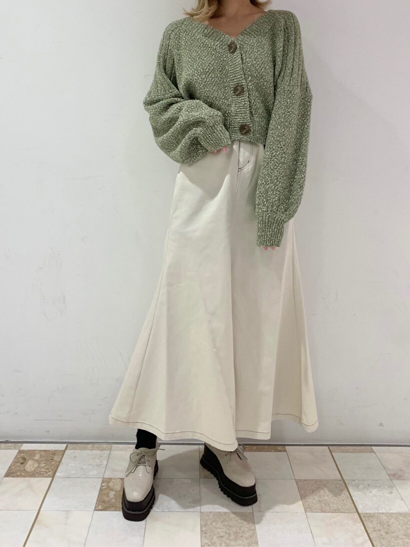 ホワイト系のローファー、ホワイト系のスカート、グリーン系のカーディガン/ボレロを着用したレディースの冬コーディネートの2枚目の写真