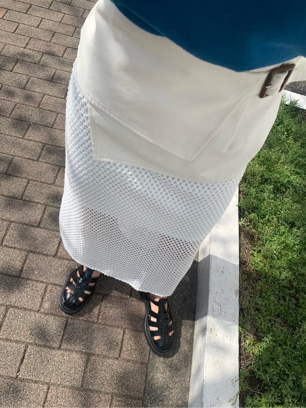 ホワイト系のスカート、ブラック系のサンダル、ブルー系のタンクトップを着用したレディースの春コーディネートの7枚目の写真