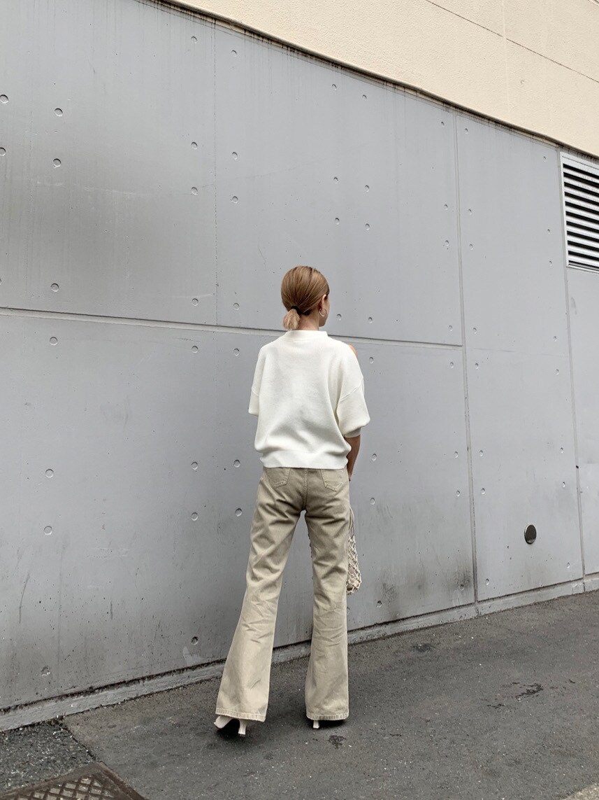 ベージュ系のその他パンツ、ホワイト系のニット/セーター、ホワイト系のハンドバッグを着用したレディースの春コーディネートの6枚目の写真