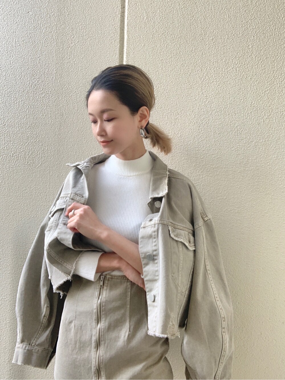 ベージュ系のデニムジャケット、ベージュ系のスカート、ホワイト系のニット/セーターを着用したレディースの冬コーディネートの3枚目の写真