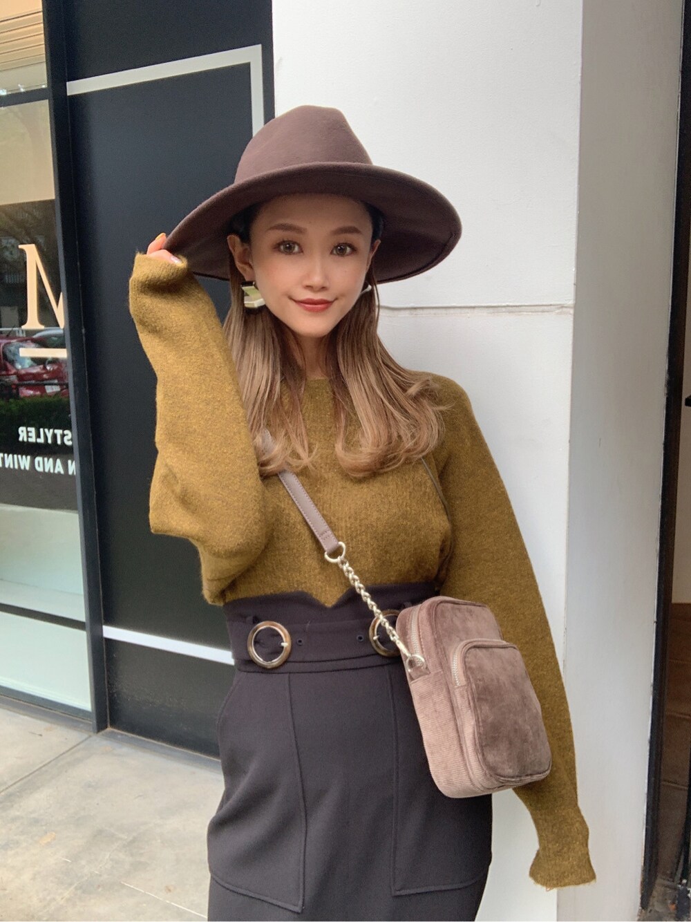 ブラック系のスカート、ブラック系のローファー、ベージュ系のニット/セーターを着用したレディースの秋コーディネートの2枚目の写真