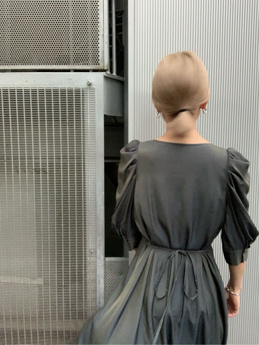 グリーン系のワンピース、ブラック系のブーツを着用したレディースの夏コーディネートの3枚目の写真