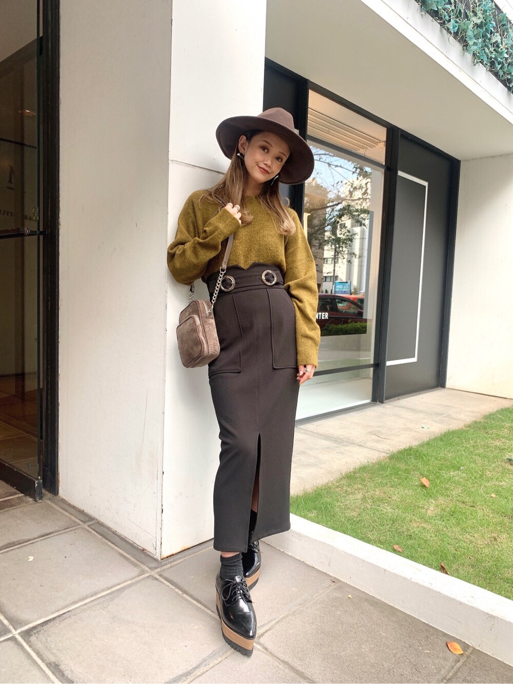 ブラック系のスカート、ブラック系のローファー、ベージュ系のニット/セーターを着用したレディースの秋コーディネートの4枚目の写真