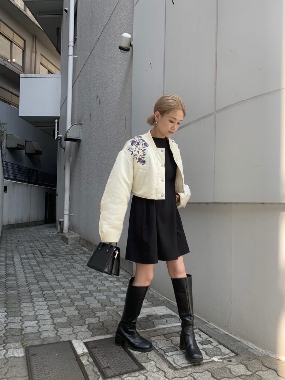 ブラック系のワンピース、ホワイト系のブルゾンを着用したレディースの夏コーディネートの2枚目の写真