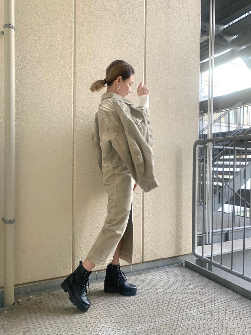 ベージュ系のデニムジャケット、ベージュ系のスカート、ホワイト系のニット/セーターを着用したレディースの冬コーディネートの2枚目の写真