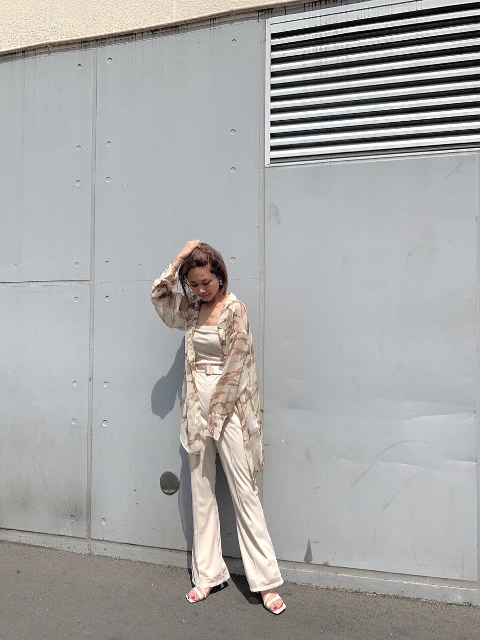 ホワイト系のスラックス、ホワイト系のサンダル、ホワイト系のTシャツ/カットソーを着用したレディースの春コーディネートの4枚目の写真