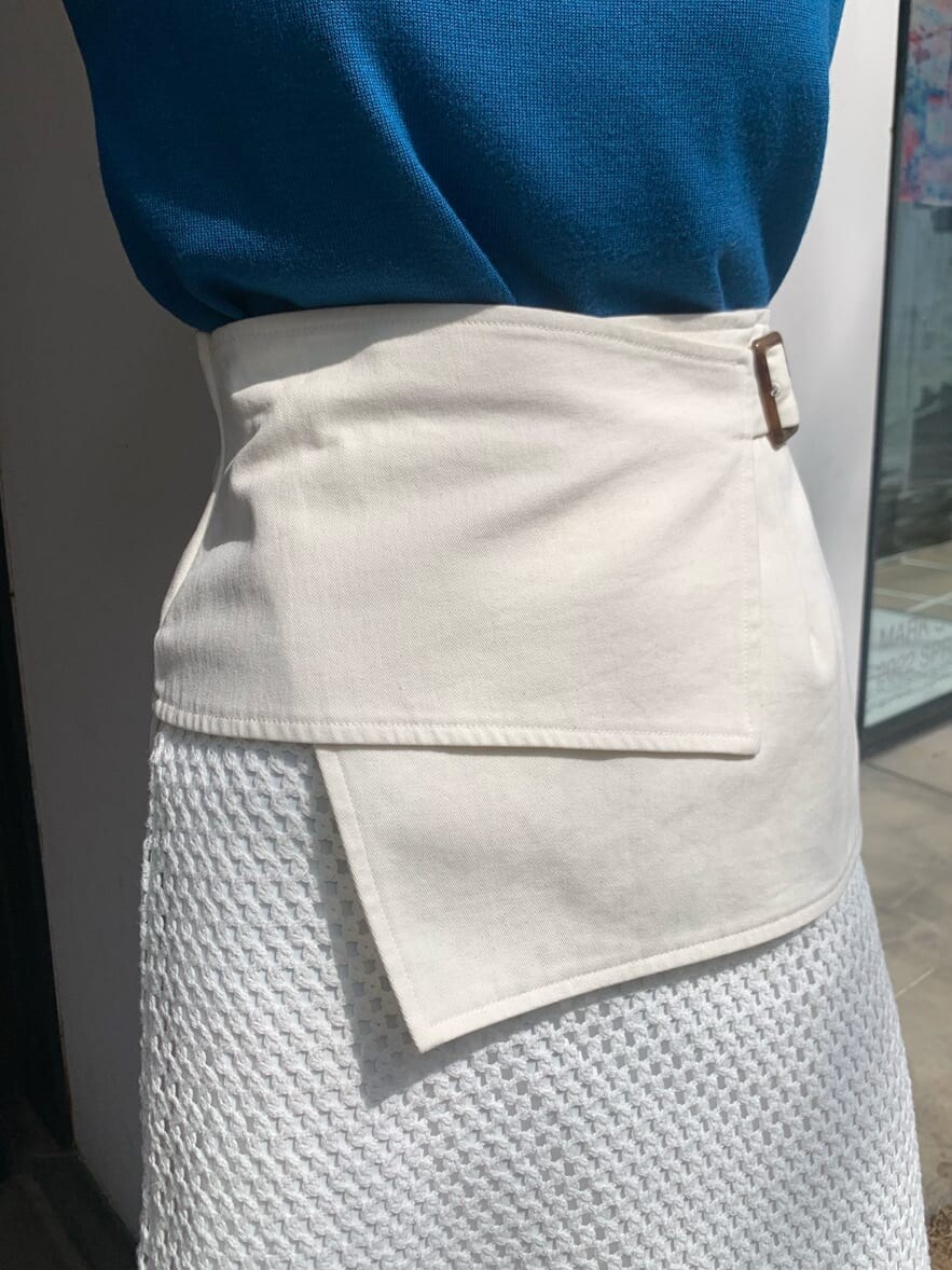 ホワイト系のスカート、ブラック系のサンダル、ブルー系のタンクトップを着用したレディースの春コーディネートの6枚目の写真