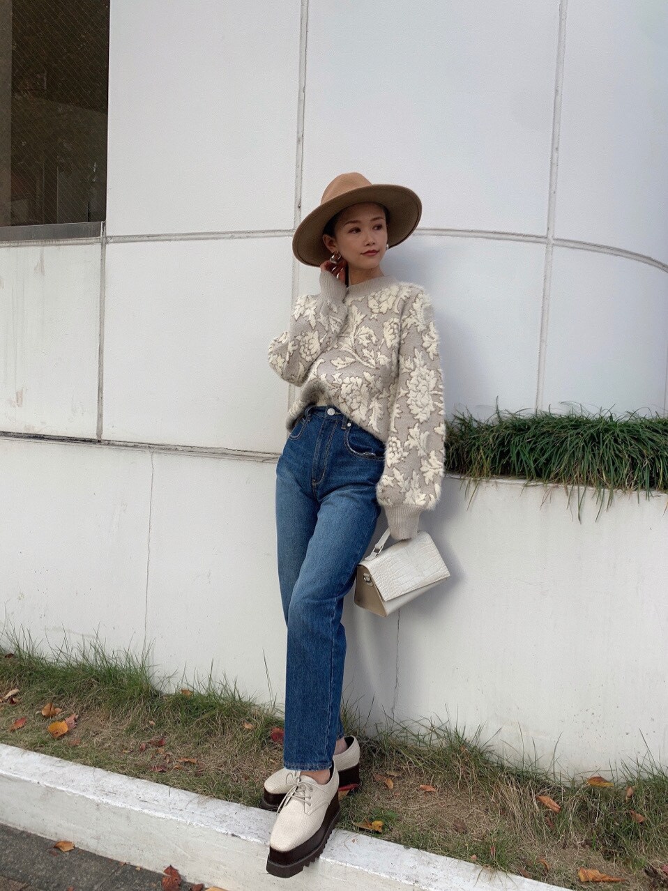 ブルー系のデニムパンツ、ホワイト系のローファー、ホワイト系のニット/セーターを着用したレディースの冬コーディネートの2枚目の写真