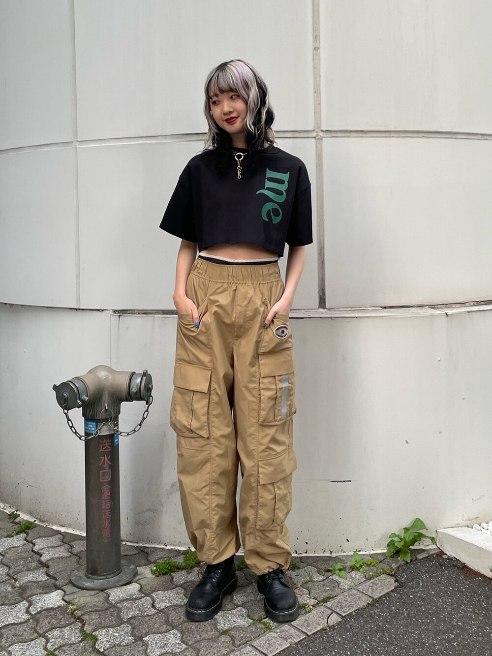ベージュ系のカーゴパンツ、ブラック系のTシャツ/カットソー、ブラック系のブーツを着用したレディースの夏コーディネートの2枚目の写真
