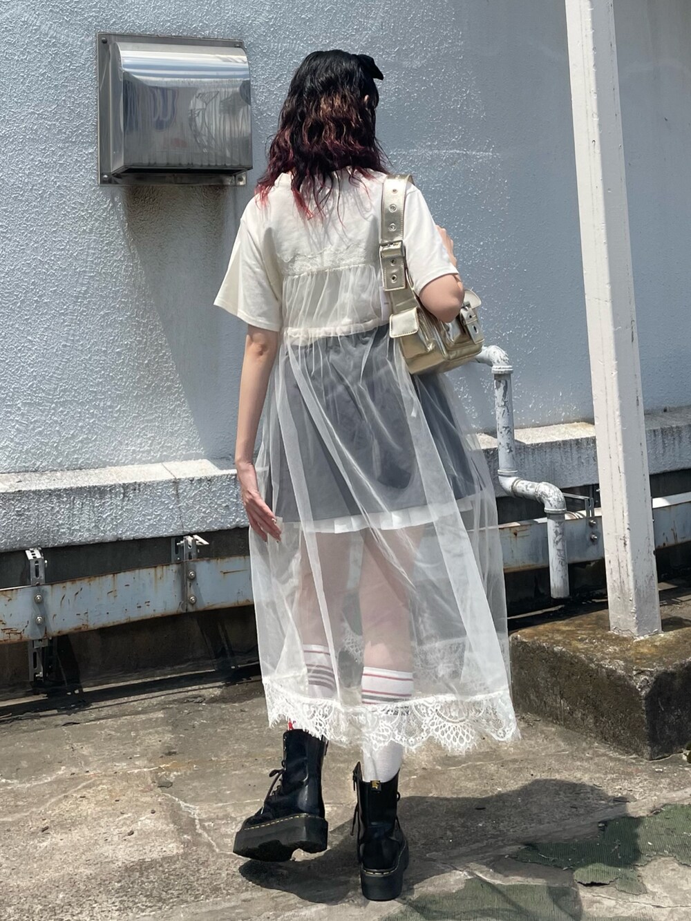 ホワイト系のワンピース、グレー系のスカート、ゴールド系のハンドバッグを着用したレディースの夏コーディネートの4枚目の写真