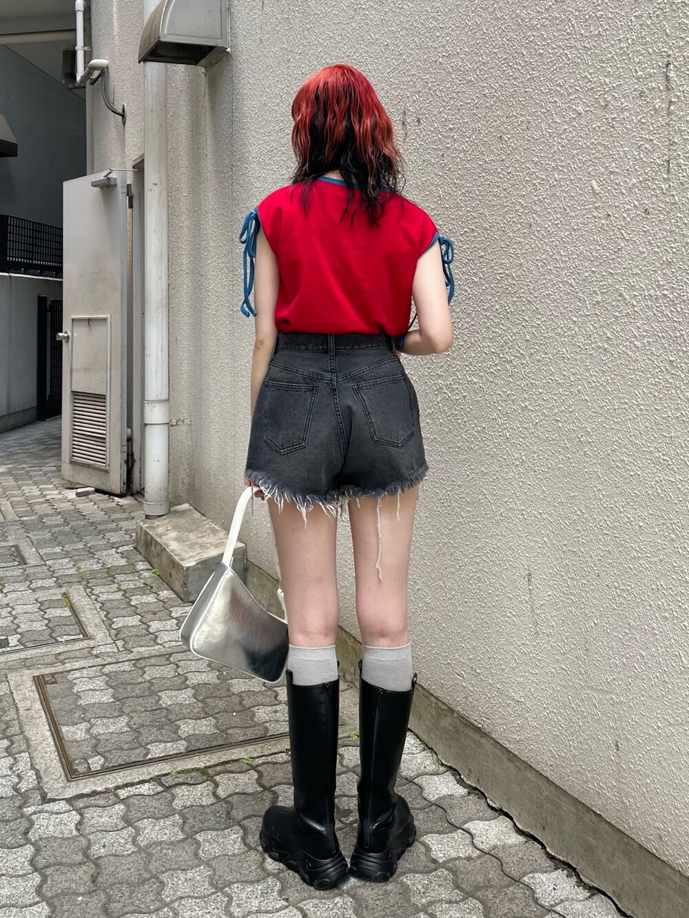 ブラック系のデニムパンツ、シルバー系のハンドバッグ、レッド系のTシャツ/カットソーを着用したレディースの夏コーディネートの3枚目の写真