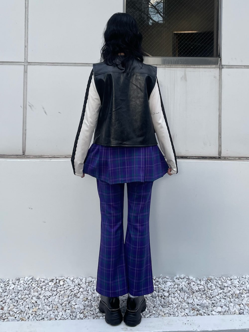 ブラック系のスニーカー、ブラック系のベスト、ホワイト系のTシャツ/カットソーを着用したレディースの冬コーディネートの4枚目の写真