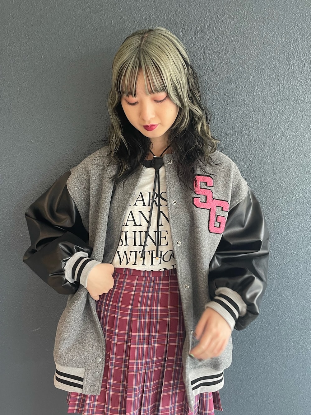 ピンク系のスカート、グレー系のスタジャン、ホワイト系のTシャツ/カットソーを着用したレディースの秋コーディネートの4枚目の写真