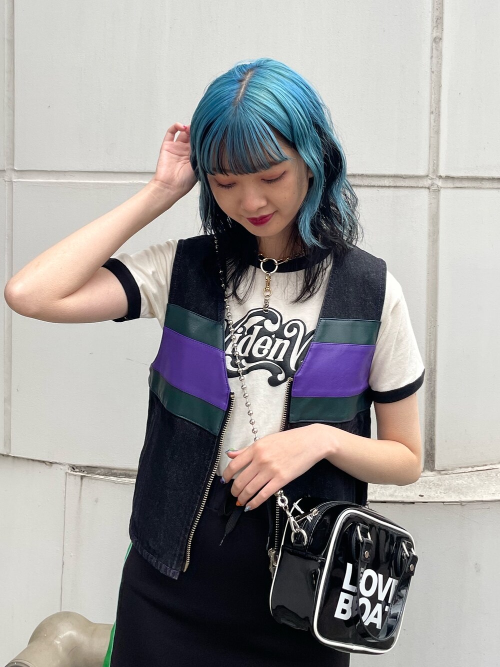 ブラック系のスカート、ブラック系のベスト、ブラック系のボストンバッグを着用したレディースの春コーディネートの4枚目の写真