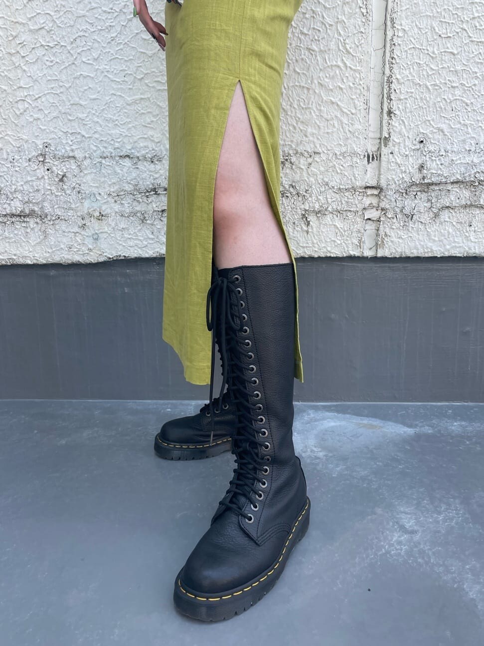 ブラック系のブーツ、グリーン系のシャツ/ブラウス、ホワイト系のTシャツ/カットソーを着用したレディースの春コーディネートの8枚目の写真