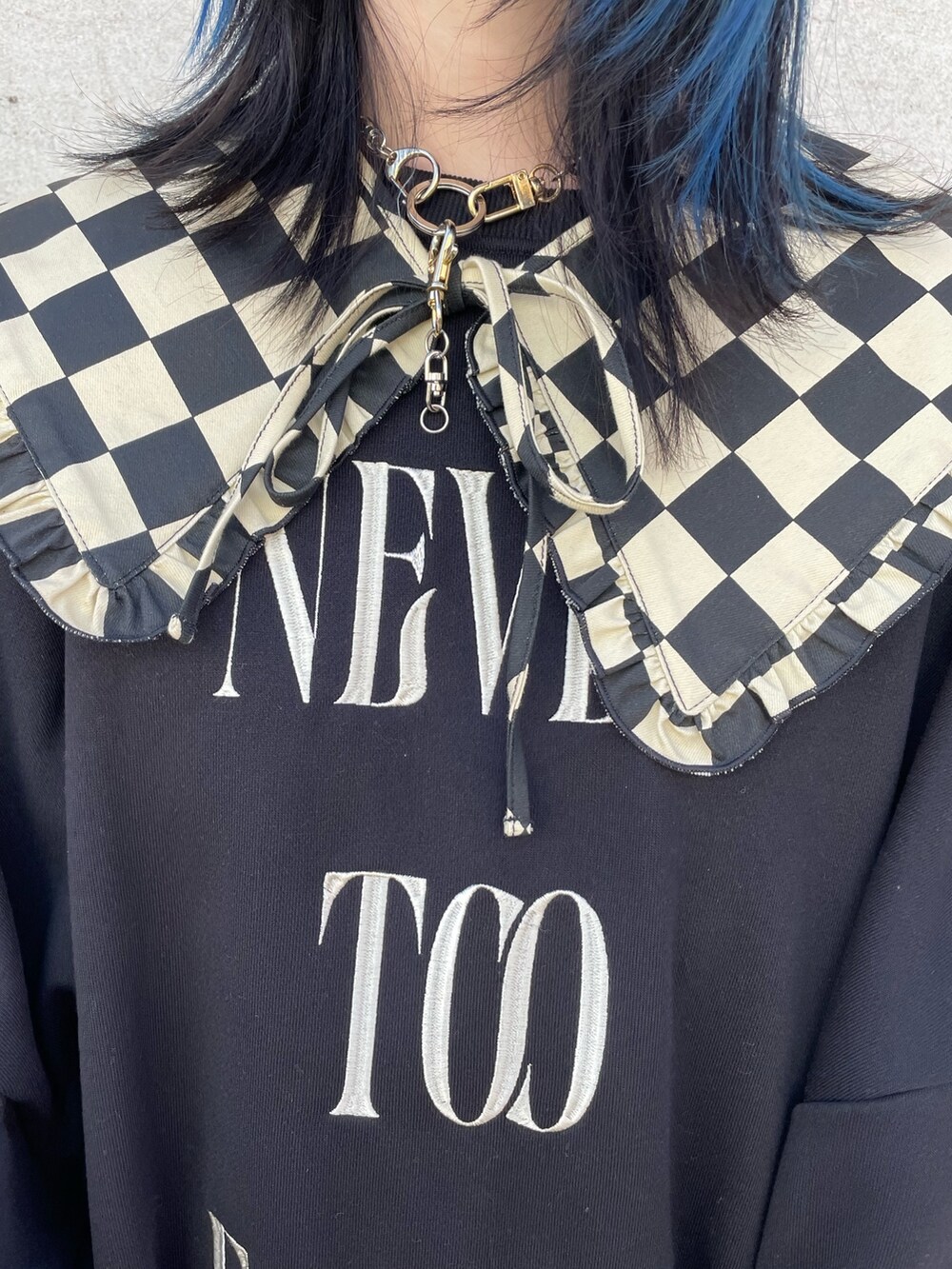 ブラック系のスウェット、レッド系のジャンパースカート、ブラック系のブーツを着用したレディースの冬コーディネートの6枚目の写真