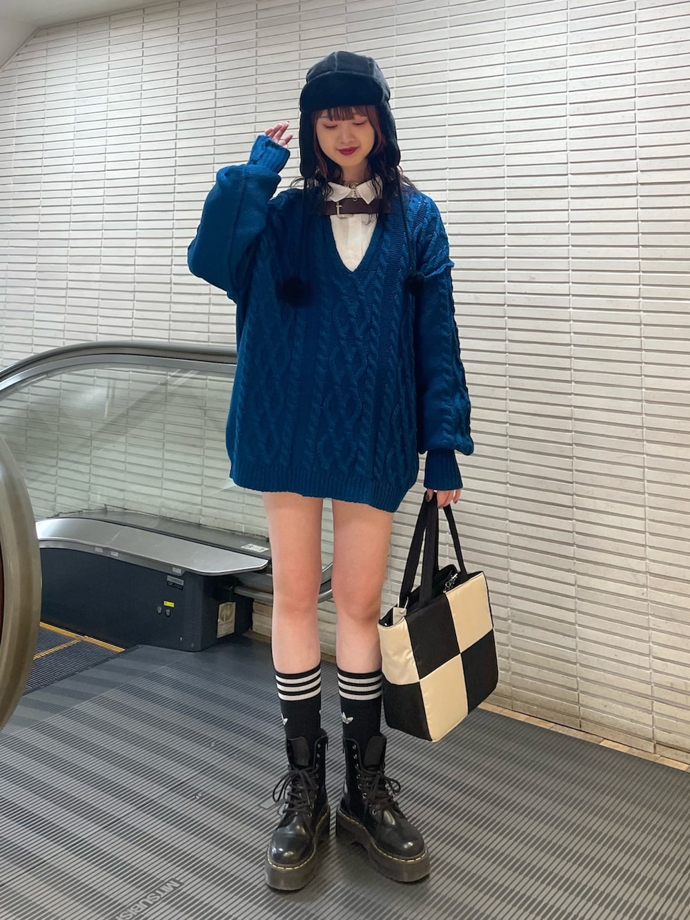 ブルー系のニット/セーター、ホワイト系のシャツ/ブラウス、ホワイト系のトートバッグを着用したレディースの冬コーディネートの2枚目の写真