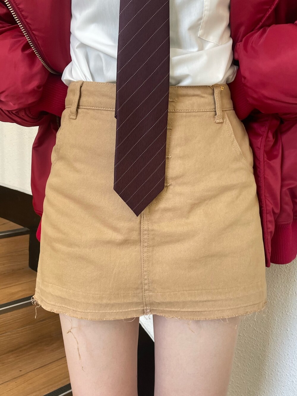 レッド系のMA-1、ホワイト系のシャツ/ブラウス、レッド系のネクタイを着用したレディースの秋コーディネートの9枚目の写真