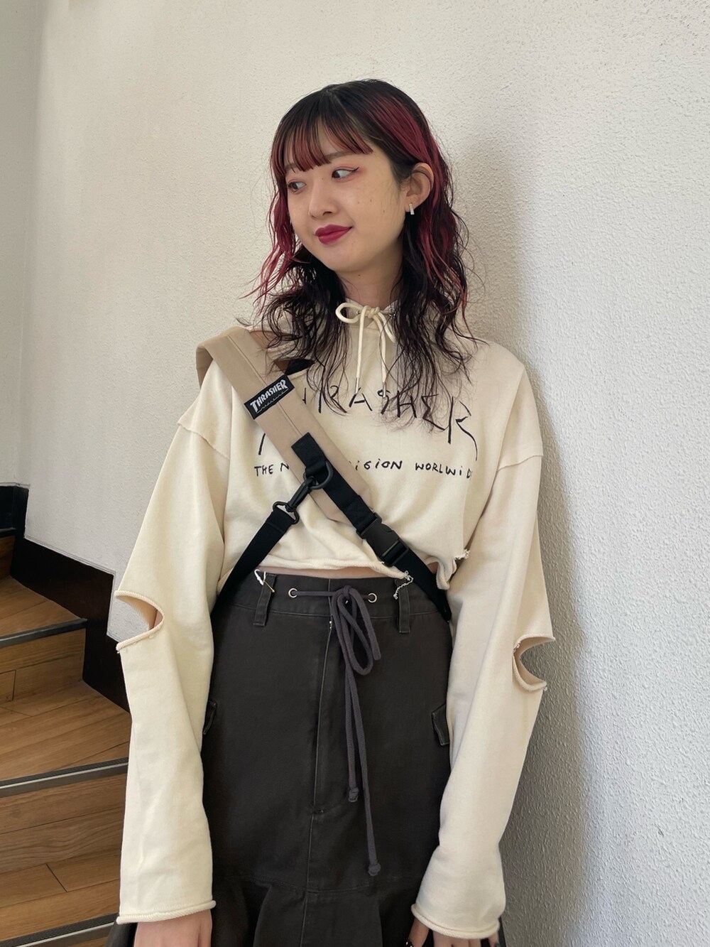 ホワイト系のパーカー、レッド系のブーツ、ブラック系のスカートを着用したレディースの春コーディネートの3枚目の写真