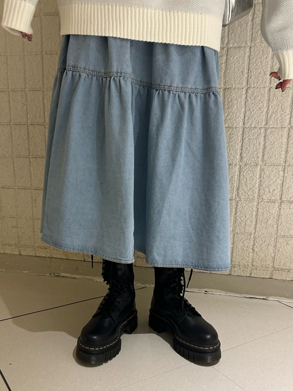 ホワイト系のニット/セーター、ブルー系のシャツ/ブラウス、シルバー系のショルダーバッグを着用したレディースの冬コーディネートの6枚目の写真