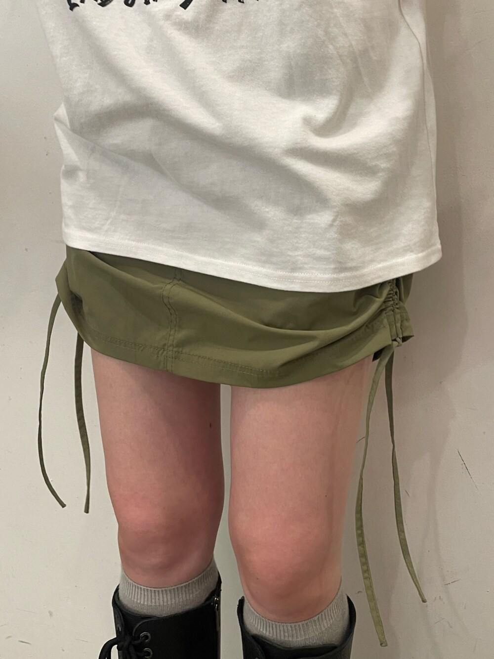 ホワイト系のTシャツ/カットソー、ブラック系のハンドバッグ、ブラック系のブーツを着用したレディースの夏コーディネートの8枚目の写真