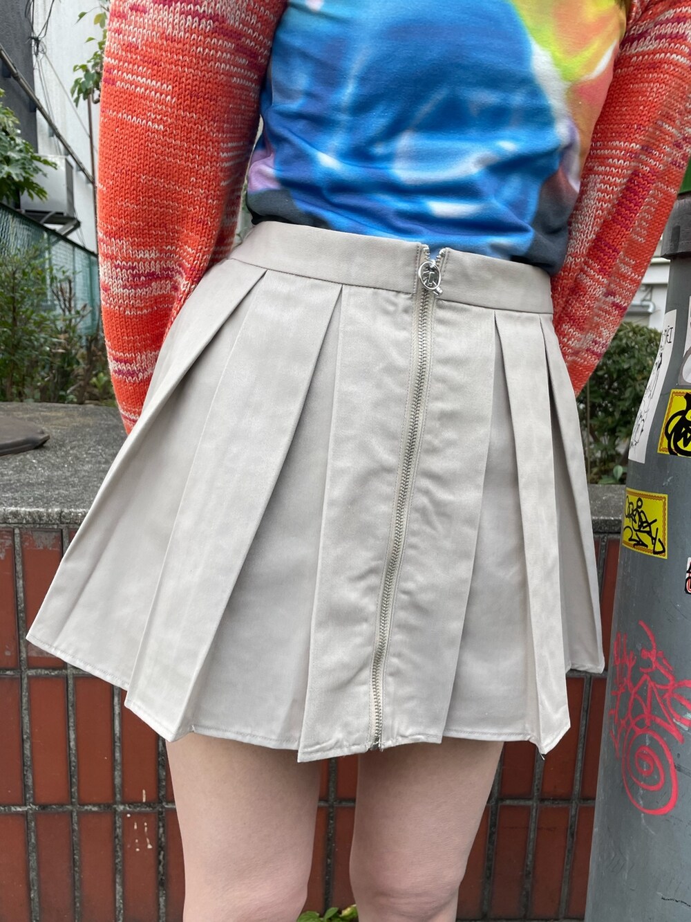 ブラック系のTシャツ/カットソー、オレンジ系のニット/セーター、ホワイト系のその他パンツを着用したレディースの冬コーディネートの7枚目の写真