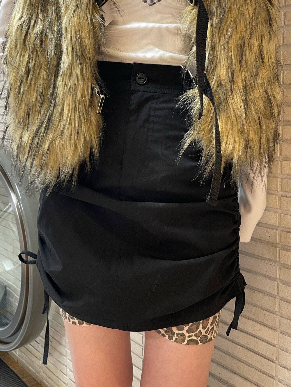 ベージュ系のベスト、ホワイト系のTシャツ/カットソー、ブラック系のスカートを着用したレディースの秋コーディネートの6枚目の写真