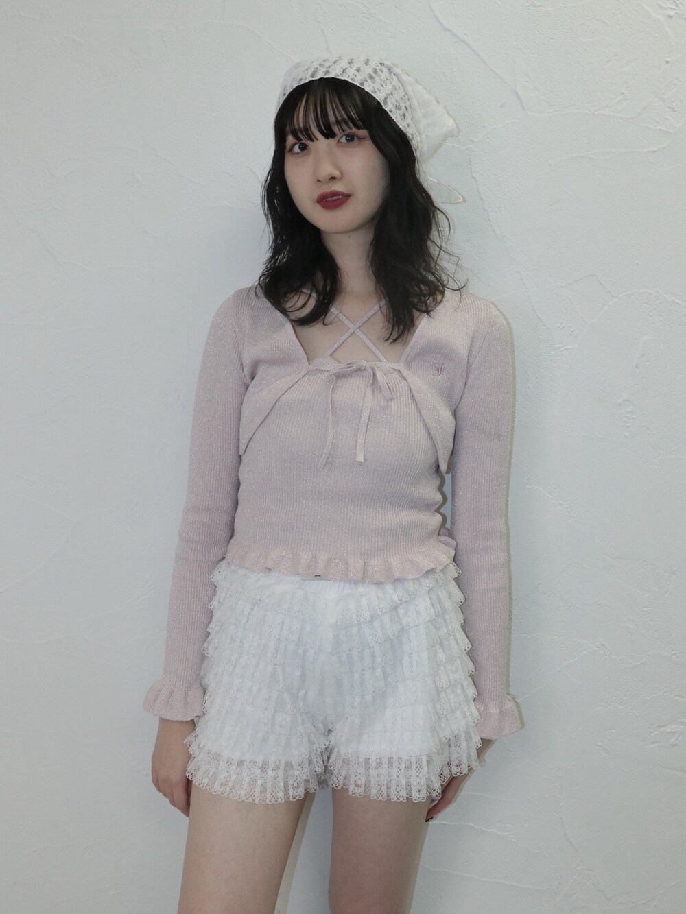 ピンク系のアンサンブル、ホワイト系のその他パンツ、ブラック系のブーツを着用したレディースの冬コーディネートの3枚目の写真