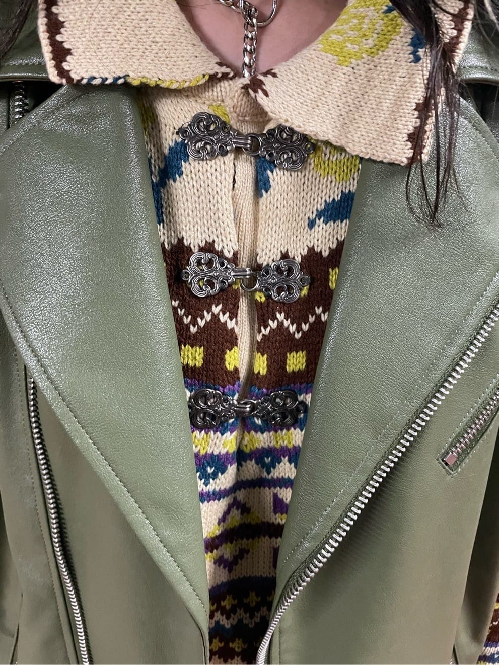 ブラック系のブーツ、ホワイト系のハンドバッグ、グリーン系のライダースジャケットを着用したレディースの秋コーディネートの7枚目の写真