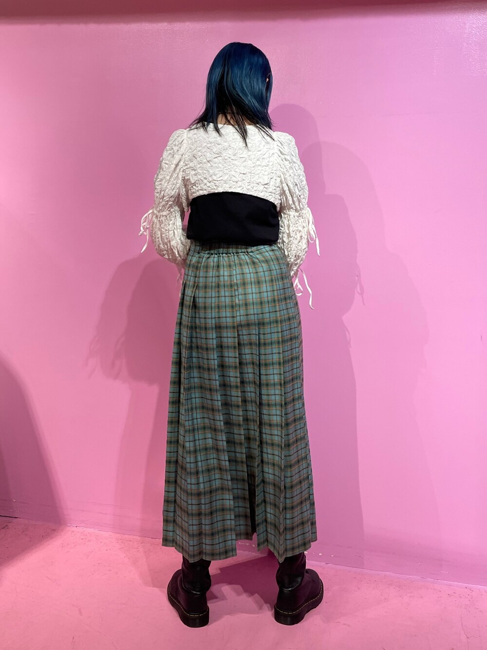 ブラック系のTシャツ/カットソー、ホワイト系のカーディガン/ボレロ、グリーン系のスカートを着用したレディースの冬コーディネートの3枚目の写真