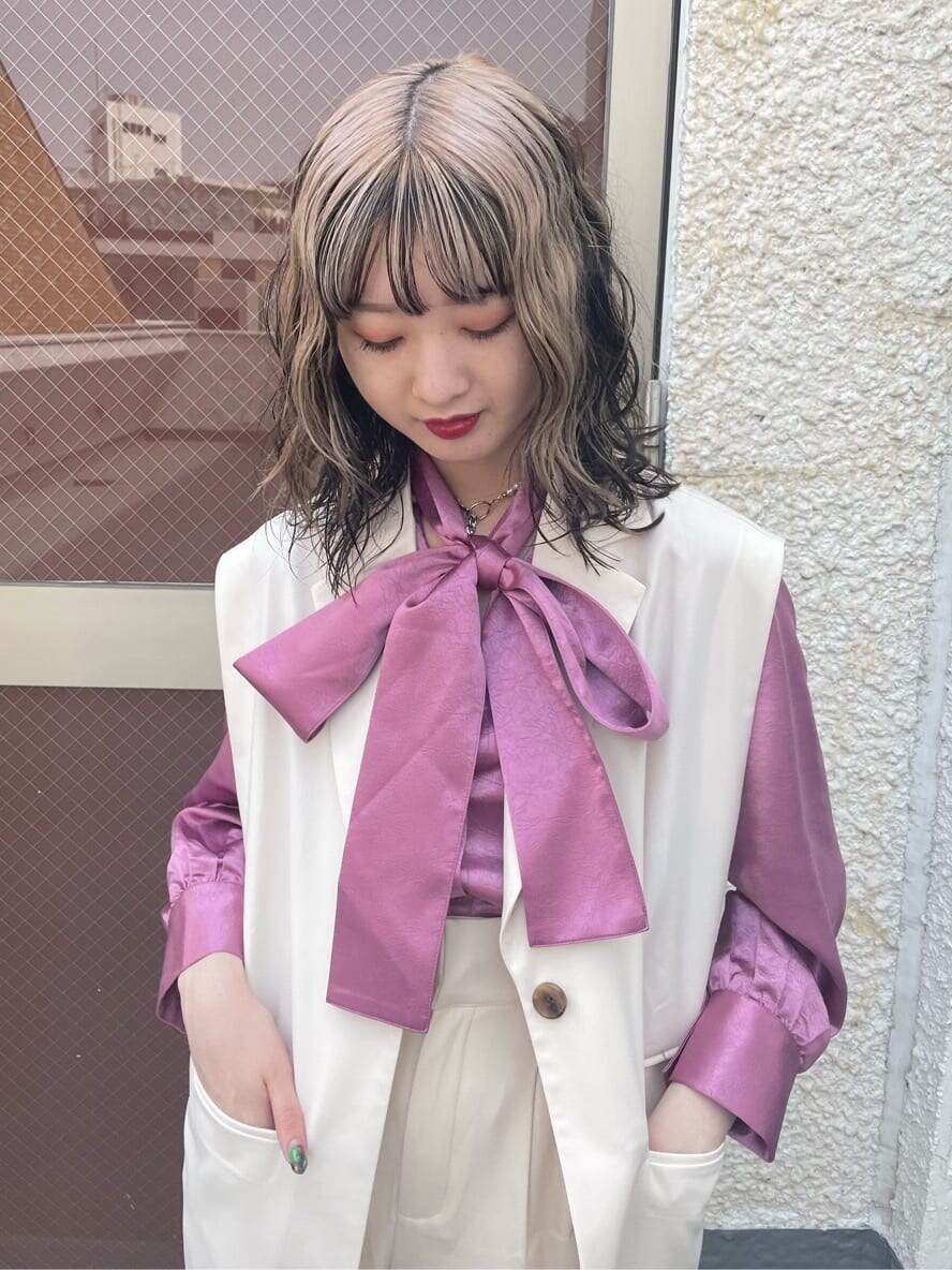 ピンク系のシャツ/ブラウス、ブラック系のブーツ、ホワイト系のベストを着用したレディースの春コーディネートの5枚目の写真