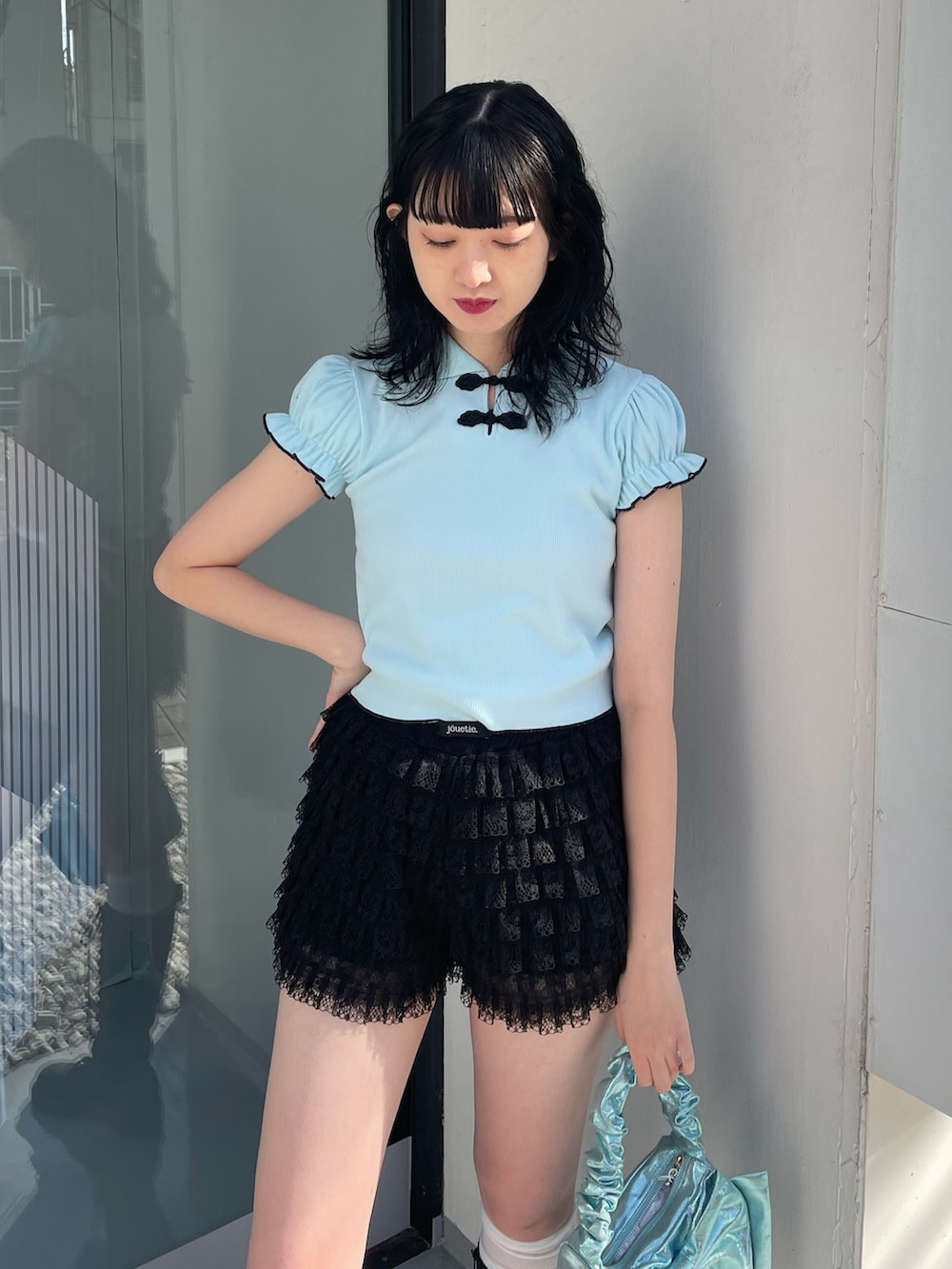 ブルー系のポロシャツ、ブラック系のその他パンツ、ブルー系のハンドバッグを着用したレディースの冬コーディネートの4枚目の写真