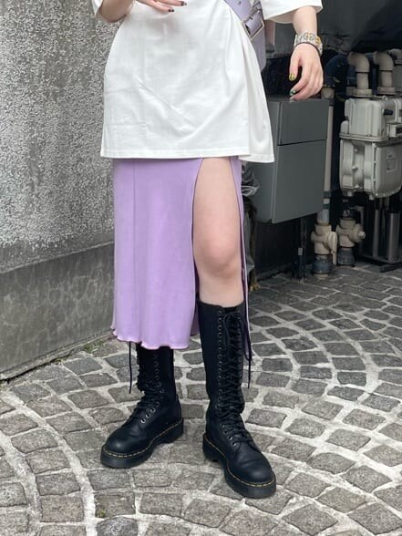 ブラック系のブーツ、パープル系のワンピース、パープル系のハンドバッグを着用したレディースの夏コーディネートの9枚目の写真