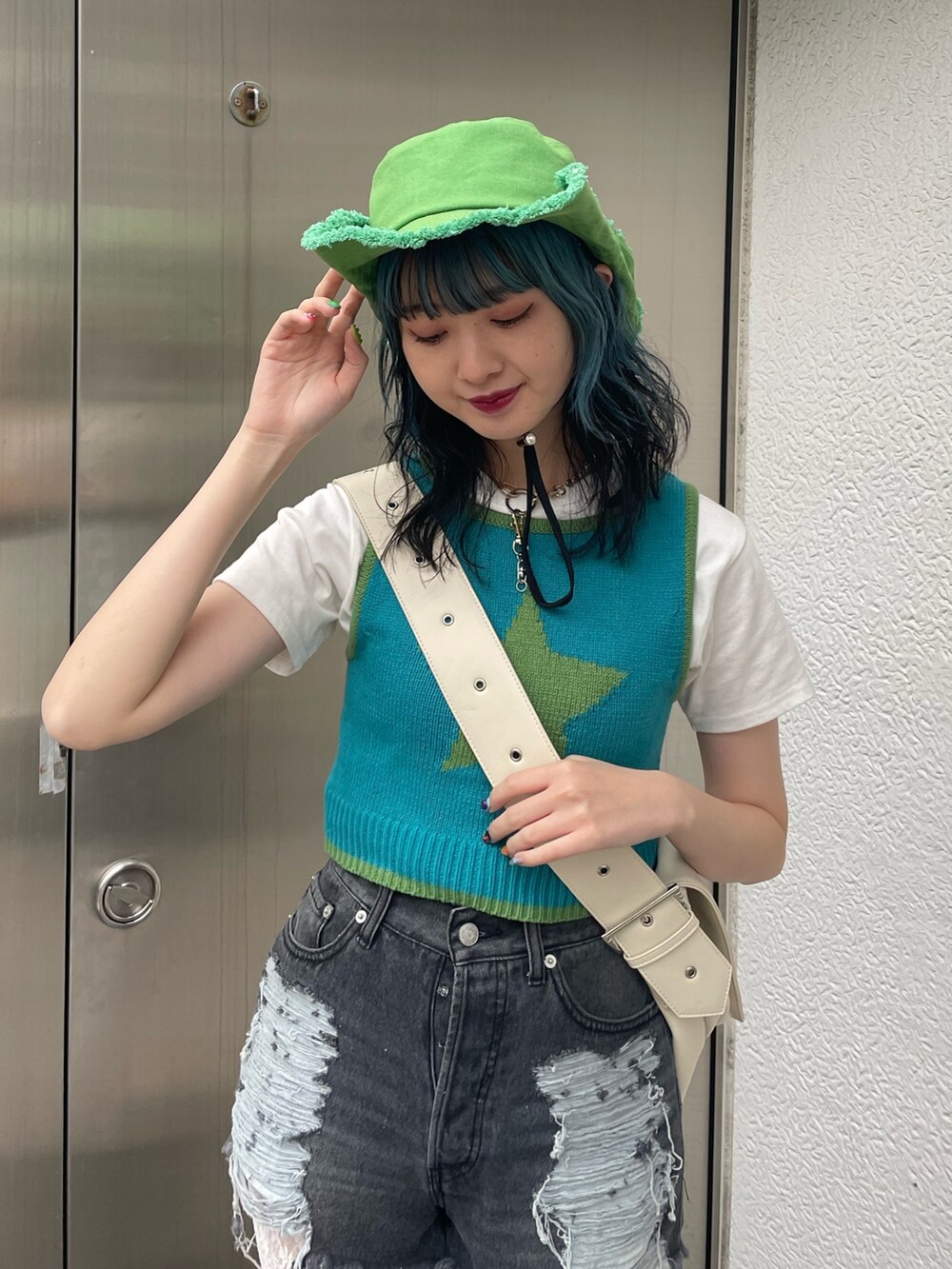 ブラック系のデニムパンツ、ブルー系のタンクトップ、ホワイト系のTシャツ/カットソーを着用したレディースの春コーディネートの4枚目の写真