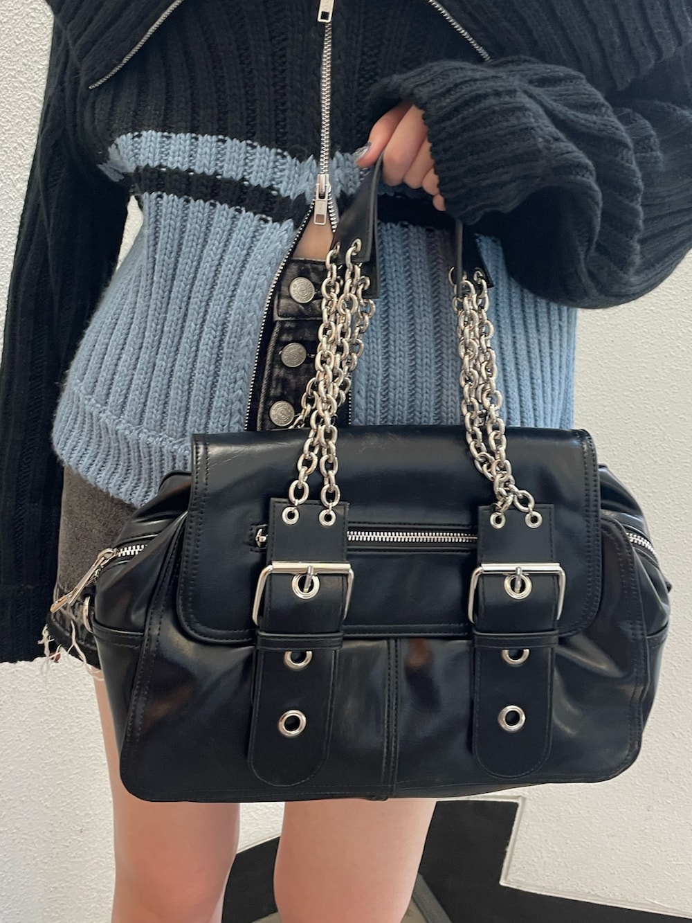 ブラック系のニット/セーター、ホワイト系のタンクトップ、ブラック系のデニムパンツを着用したレディースの秋コーディネートの7枚目の写真