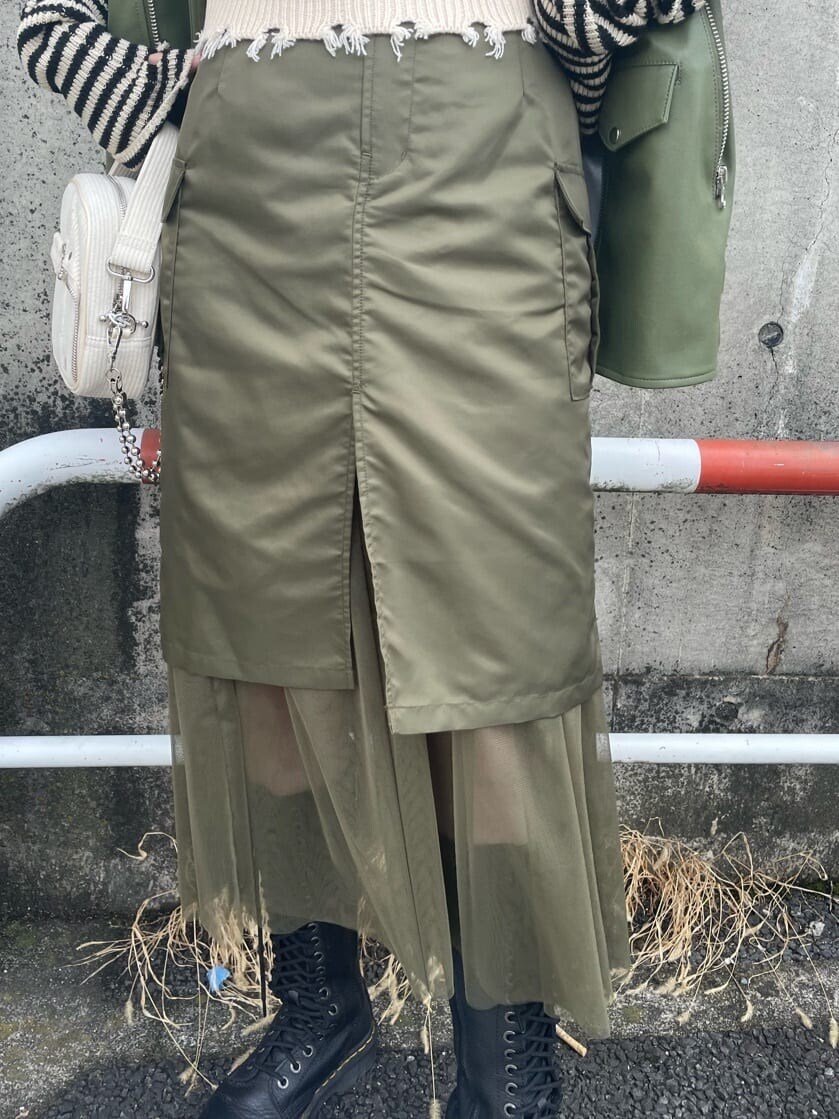 ブラック系のブーツ、ベージュ系のスカート、ホワイト系のベストを着用したレディースの秋コーディネートの6枚目の写真