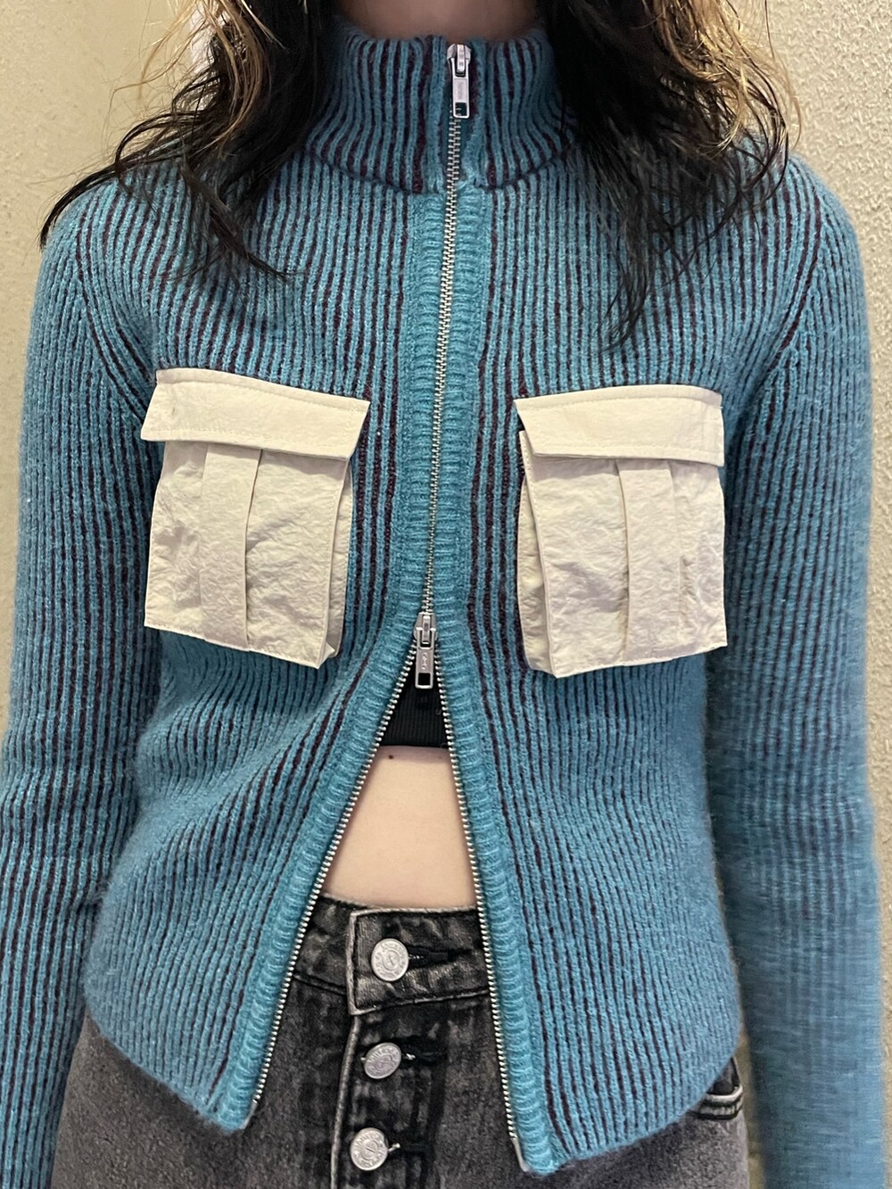 ブルー系のニット/セーター、ブラック系のデニムパンツ、ホワイト系のトートバッグを着用したレディースの秋コーディネートの5枚目の写真