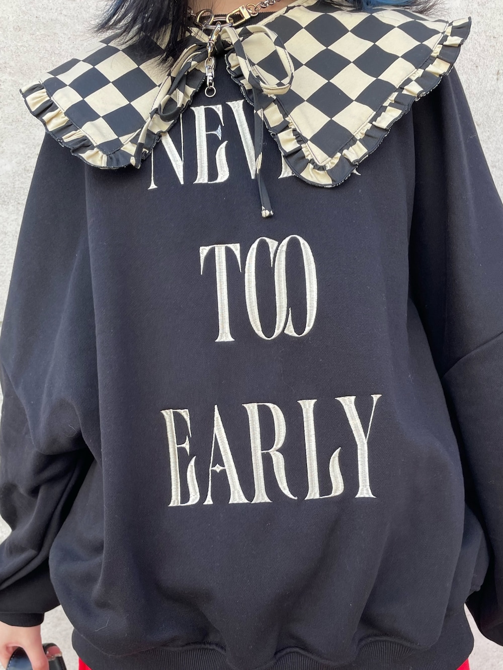 ブラック系のスウェット、レッド系のジャンパースカート、ブラック系のブーツを着用したレディースの冬コーディネートの5枚目の写真