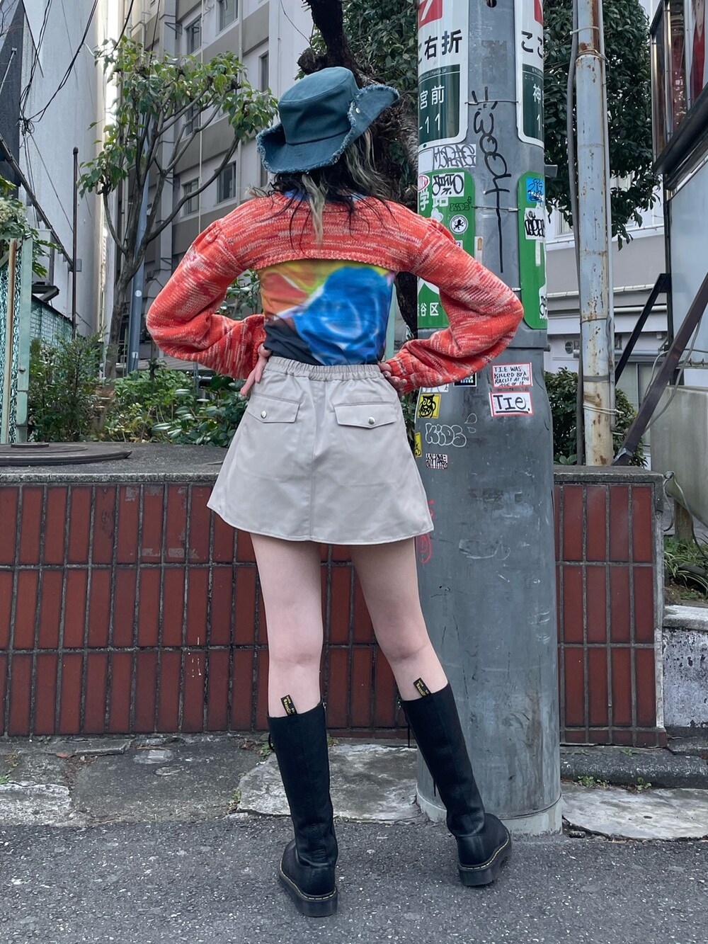 ブラック系のTシャツ/カットソー、オレンジ系のニット/セーター、ホワイト系のその他パンツを着用したレディースの冬コーディネートの3枚目の写真