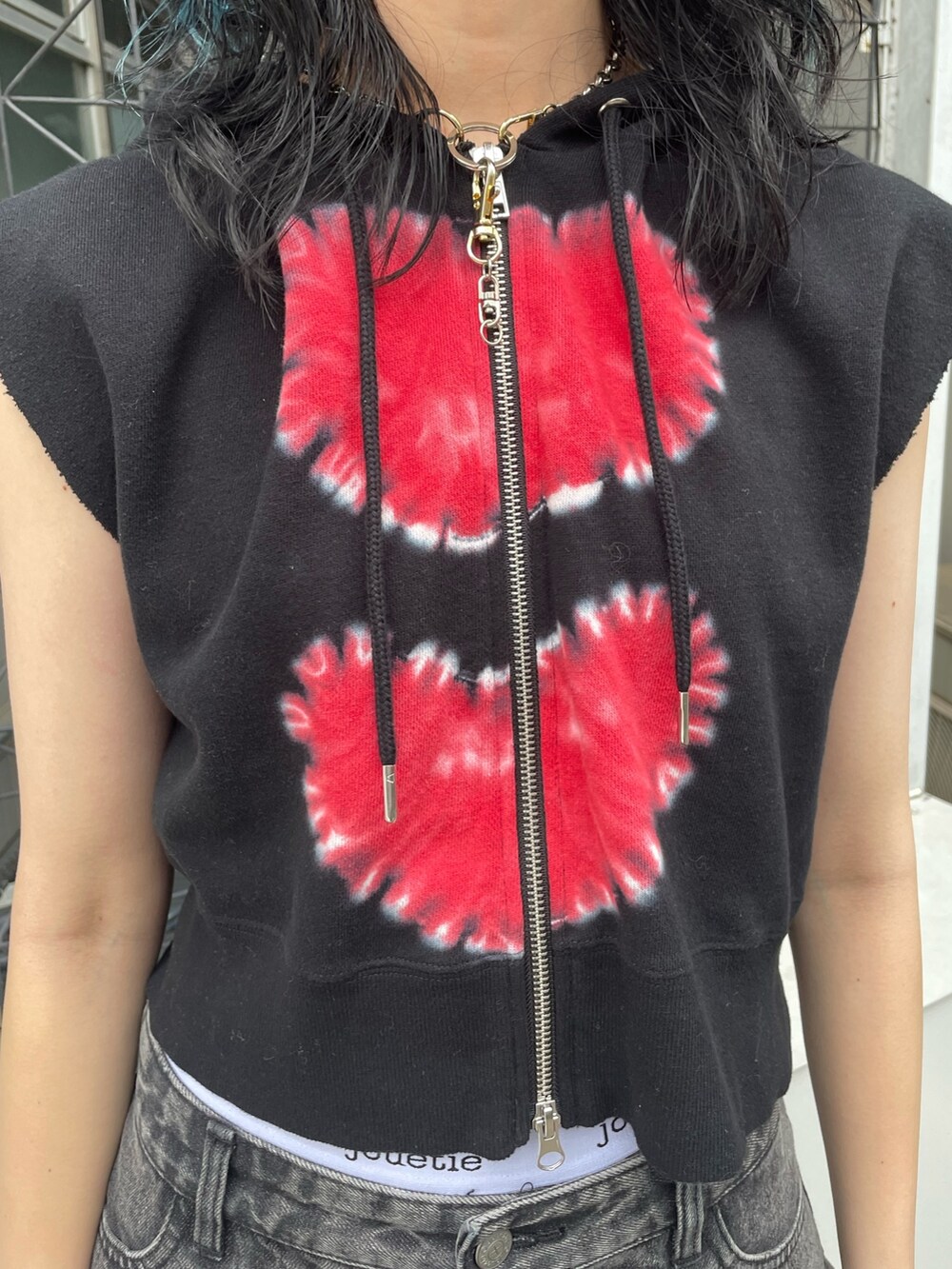 ブラック系のタンクトップ、ブラック系のデニムパンツ、シルバー系のサンダルを着用したレディースの春コーディネートの5枚目の写真