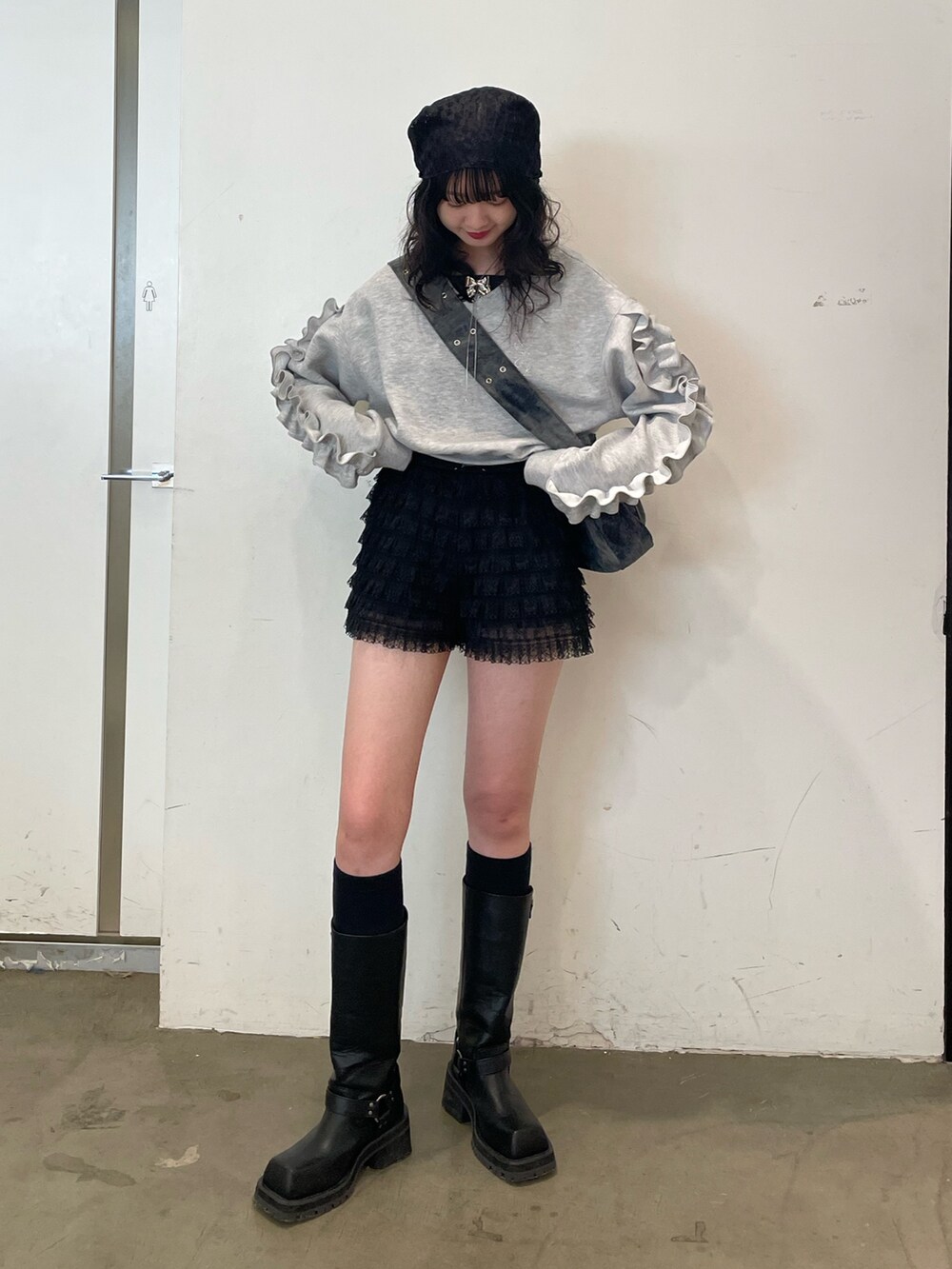 グレー系のスウェット、ブラック系のブーツ、ブラック系のその他パンツを着用したレディースの冬コーディネートの2枚目の写真